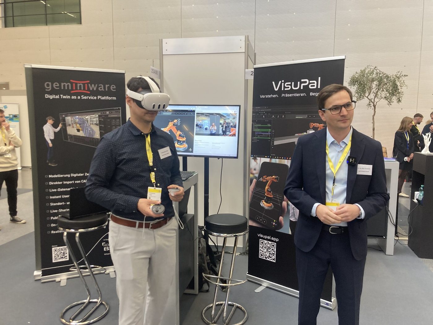 Teammitglieder am Messestand: VR-Demo eines Digitalen Zwillings mit VisuPal